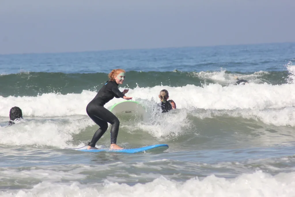 Anfängerin erwischt eine Welle beim Surfkurs in der Taghazout Bay